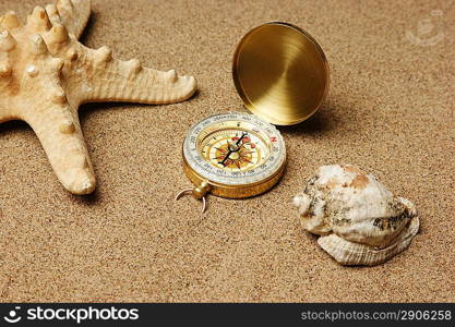 compass and starfish on a sandy beach