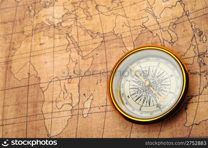 Compass on old map. Gold comapss and yellow map