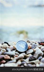Compass on the beach, small stones, text space