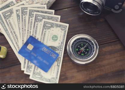 compass, passport, credit card, banknote, camera,map, car figurine on wooden table for use as traveling concept (vintage tone and selected focus)