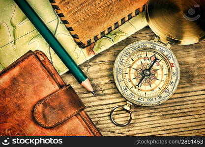 compass wallet and passport on a wooden table