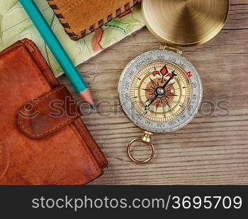 compass wallet and passport on a wooden table