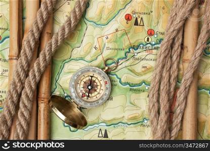 Compass with ropes and bamboo on a topographic map
