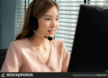 Competent female operator working on computer and while talking with clients. Concept relevant to both call centers and customer service offices.. Competent female operator working on computer and while talking with clients.