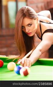 Competition concept. Young girl having fun with billiard. Beautiful fashionable woman playing spending time on entertainment.. Young fashionable girl playing billiard.
