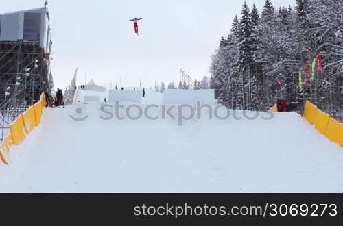 competitions in freestyle (aerial skiing), professional aerialist performs double backflips and two twists from medium-sized ski jump, good performance