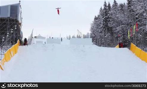 competitions in freestyle (aerial skiing), professional aerialist performs double backflips and two twists from medium-sized ski jump, good performance