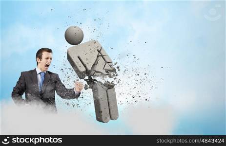 Competitive business. Angry young businessman fighting with stone opponent