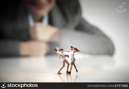 Competitive business. Businesswoman looking at two sport girls boxing in gloves