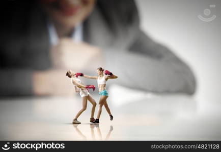 Competitive business. Businesswoman looking at two sport girls boxing in gloves