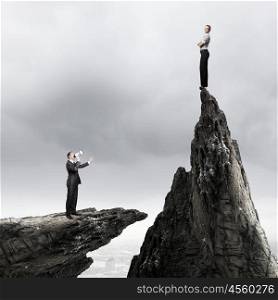 Competitive business. Businesswoman standing on top of rock and businessman screaming in megaphone
