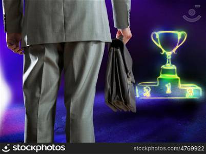 Competitive business. Rear view of businessman with briefcase and podium with cup