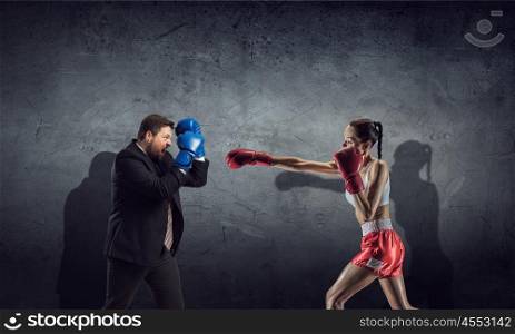 Competitive spirit in business. Businessman in suit fighting opponent in concrete room