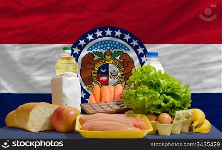 complete american state flag of missouri covers whole frame, waved, crunched and very natural looking. In front plan are fundamental food ingredients for consumers, symbolizing consumerism an human needs