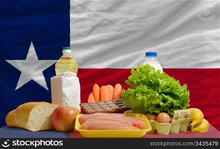 complete american state flag of texas covers whole frame, waved, crunched and very natural looking. In front plan are fundamental food ingredients for consumers, symbolizing consumerism an human needs