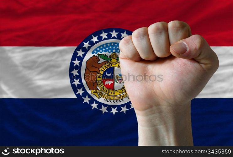 complete american state of missouri flag covers whole frame, waved, crunched and very natural looking. In front plan is clenched fist symbolizing determination