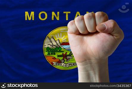 complete american state of montana covers whole frame, waved, crunched and very natural looking. In front plan is clenched fist symbolizing determination