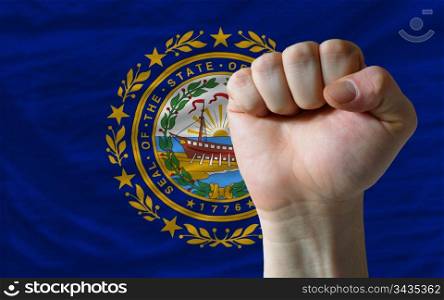 complete american state of new hampshire covers whole frame, waved, crunched and very natural looking. In front plan is clenched fist symbolizing determination