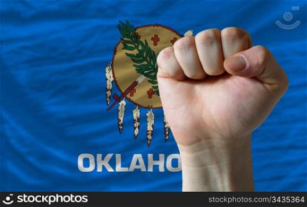 complete american state of oklahoma covers whole frame, waved, crunched and very natural looking. In front plan is clenched fist symbolizing determination