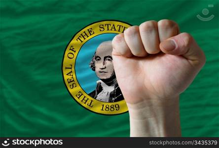 complete american state of washington flag covers whole frame, waved, crunched and very natural looking. In front plan is clenched fist symbolizing determination