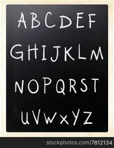 Complete english alphabet handwritten with white chalk on a blackboard