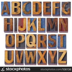 complete English alphabet set - collage of 26 isolated vintage wood letterpress printing blocks, scratched and stained by blue, red and black ink, digital painting filter applied