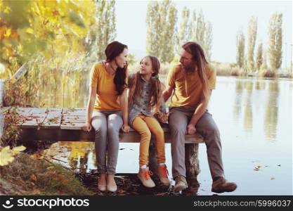 Complete family sitting by the lake