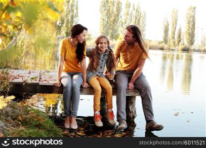Complete family sitting by the lake