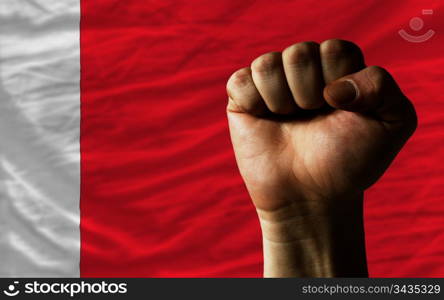 complete national flag of bahrain covers whole frame, waved, crunched and very natural looking. In front plan is clenched fist symbolizing determination