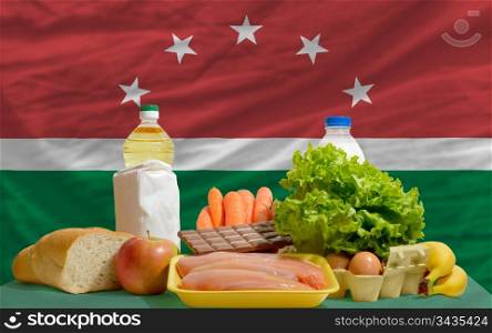 complete national flag of maghreb covers whole frame, waved, crunched and very natural looking. In front plan are fundamental food ingredients for consumers, symbolizing consumerism an human needs