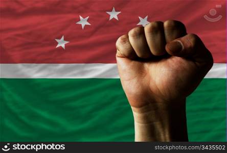 complete national flag of maghreb covers whole frame, waved, crunched and very natural looking. In front plan is clenched fist symbolizing determination