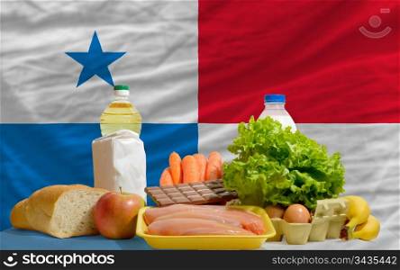 complete national flag of panama covers whole frame, waved, crunched and very natural looking. In front plan are fundamental food ingredients for consumers, symbolizing consumerism an human needs