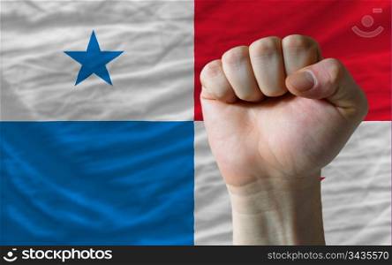 complete national flag of panama covers whole frame, waved, crunched and very natural looking. In front plan is clenched fist symbolizing determination
