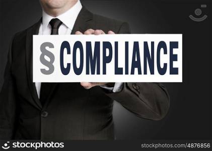 compliance placard is held by businessman. compliance placard is held by businessman.