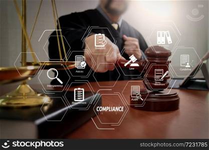 Compliance Virtual Diagram for regulations, law, standards, requirements and audit.Male judge in a courtroom with the gavel,working with smart phone and digital tablet computer with brass scale on wood table