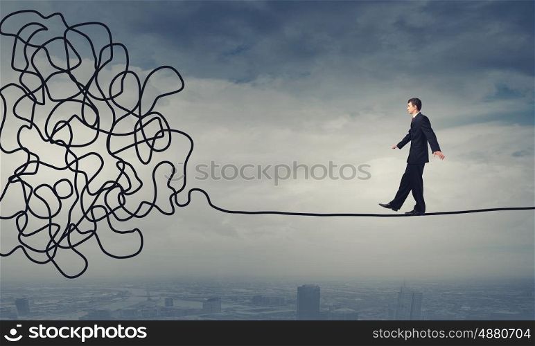 Complicated case. Businessman walking on twisted rope high in sky