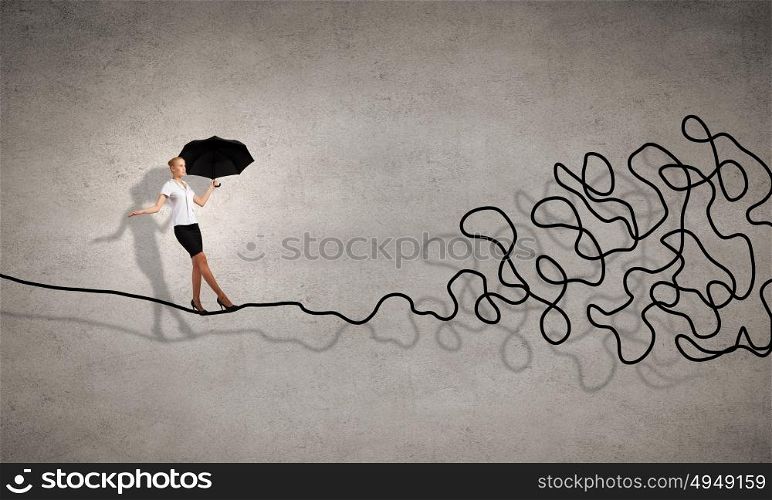 Complicated case. Young businesswoman walking on twisted rope high in sky