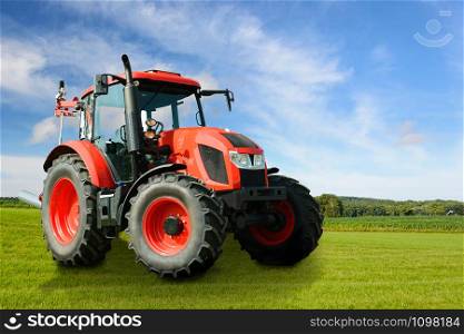Composite image of a modern red agricultural generic tractor on a green field on a sunny day.