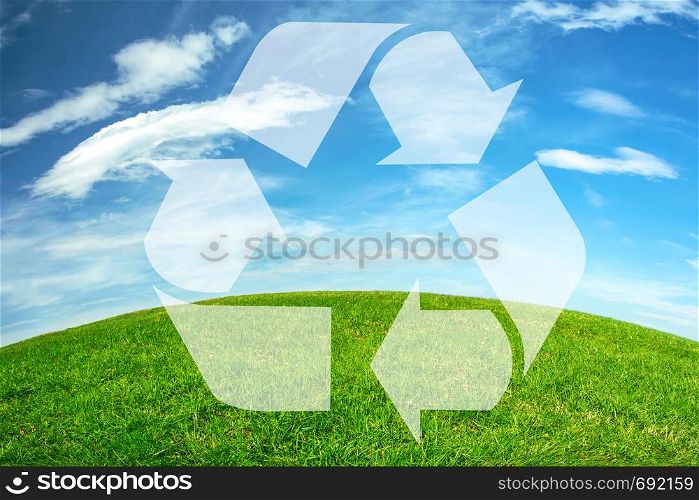 Composite image of an environmental conservation - recycle sign on a green meadow and blue sky earth horizon