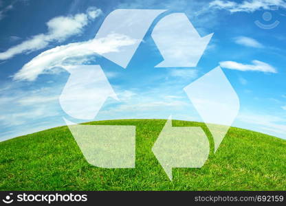 Composite image of an environmental conservation - recycle sign on a green meadow and blue sky earth horizon