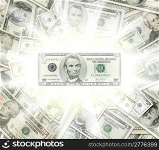 Composite shot of American Dollars piled together with 5 Dollar Lincoln bill glowing in the front.