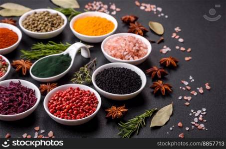 Composition consisting of a variation of several types of spices in white ceramic bowls on a textured concrete background
