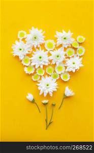 Composition of flowers on yellow paper background.