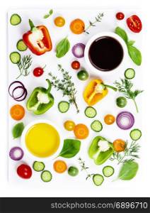 Composition of Fresh organic vegetables (pepper, onion, cucumber, carrot, tomatoe), herbs, olive oil and vinegar isolated on white background, top view