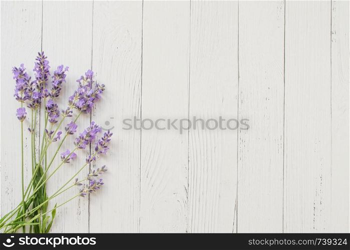 Composition of lavender on wooden background. Fresh summer flowers. Free space. Composition of lavender on white wooden background. Violet summer flowers. Free space