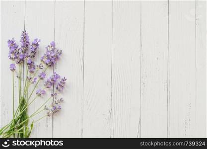 Composition of lavender on wooden background. Fresh summer flowers. Free space. Composition of lavender on white wooden background. Violet summer flowers. Free space
