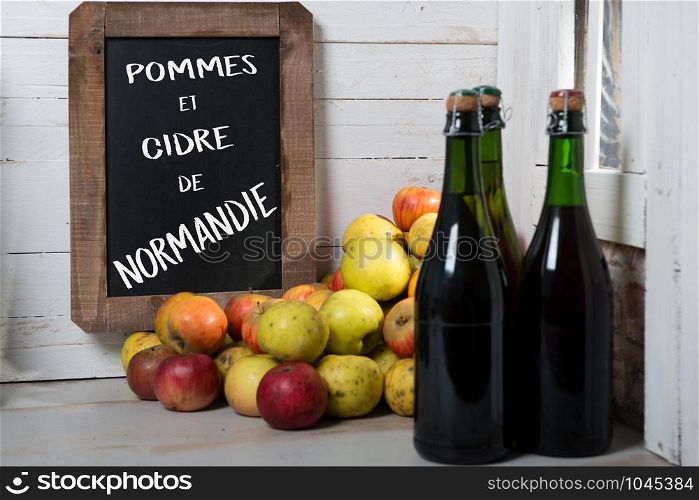 composition of organic fresh apples and bottle of Normandy cider with chalkboard