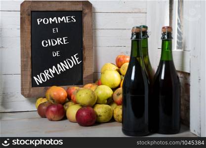 composition of organic fresh apples and bottle of Normandy cider with chalkboard