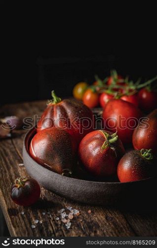 Composition of variety mix colorful tomatoes. Fresh tomatoes on Rustic stile dark background.. Mix colorful tomatoes