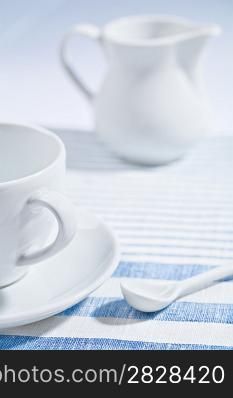 composition of white cup and spoon and jug